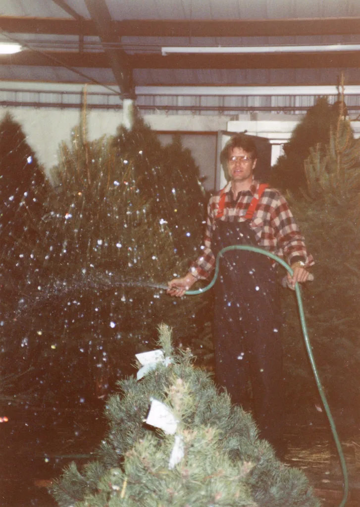 heritage-molly-browns-christmas-forest-watering Historic photo of Molly Brown’s Christmas Forest owner, Steve, watering rows of Christmas trees inside a warehouse.
