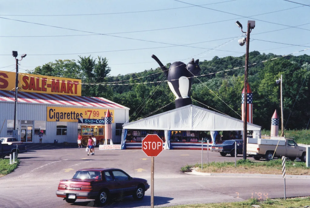 heritage-molly-browns-fireworks-sale-mart Historic Molly Brown’s Fireworks roadside stand with a white sales tent, rocket decorations, and a large inflatable black cat on the roof.